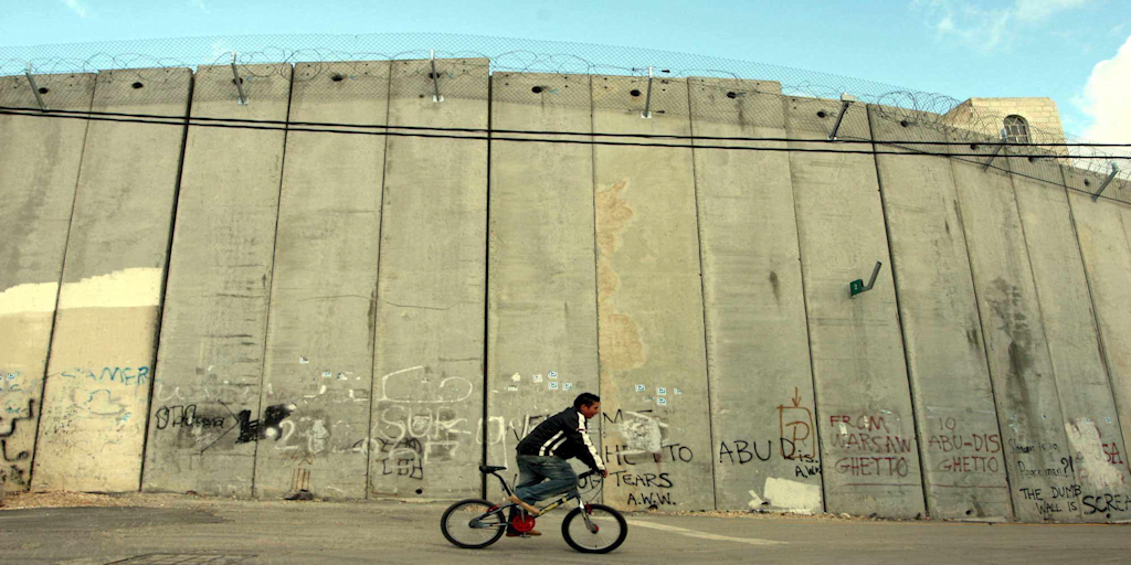 Palestinian boy on a bike near Israel's apartheid wall