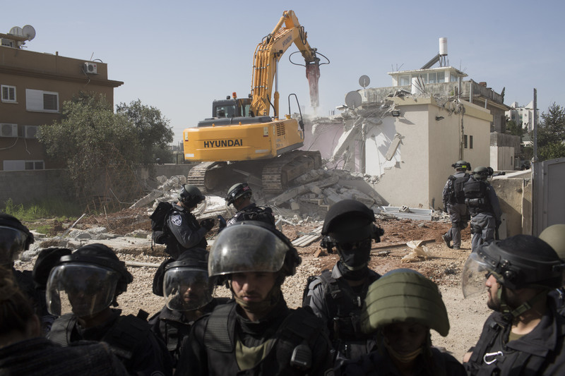 Israeli authorities use a Hyundai bulldozer to destroy the home of a Palestinian citizen of Israel in the town of Lydd, Feb 10 2015. The house belonged to a single mother and her four children. (Oren Ziv, ActiveStills)