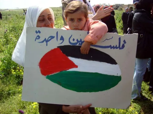 Palestinian_child_holds_a_sign_on_Land_Day.jpg
