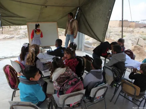 Palestinian students have their lessons inside a tent after Israeli forces demolished a primary school in Hebron, West Bank