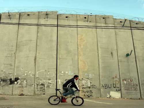 Palestinian boy on a bike near Israel's apartheid wall