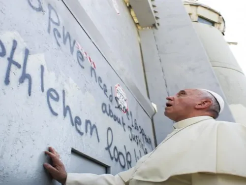Pope Francis touches Israel's wall on his way to celebrate a mass in the Palestinian West Bank city of Bethlehem May 25, 2014
