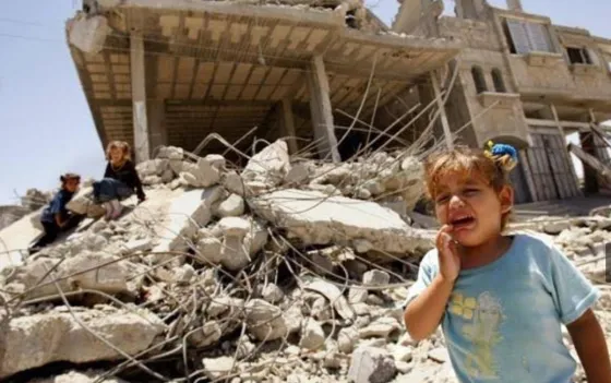 Gazan girl in front of ruins of destroyed home